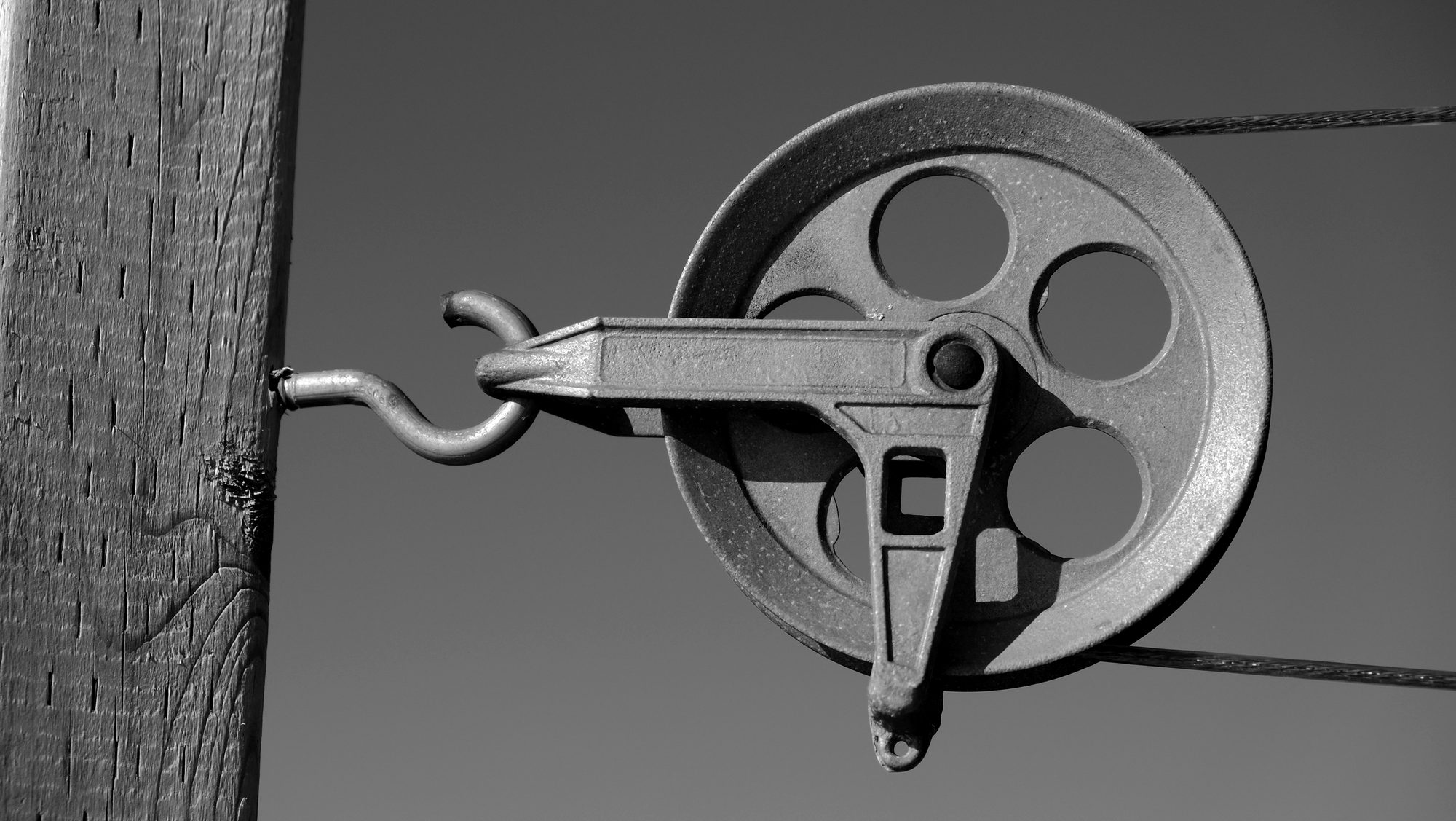 A pulley mechanism against the sky, an image of the work being done quietly above